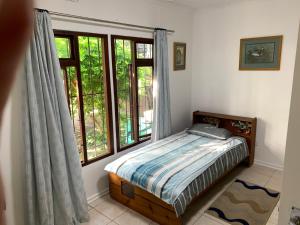 a bedroom with a bed and a large window at Peace Cottage in St Lucia