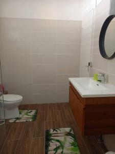 a bathroom with a sink and a toilet and a mirror at Maison au bord de mer in Sainte-Rose