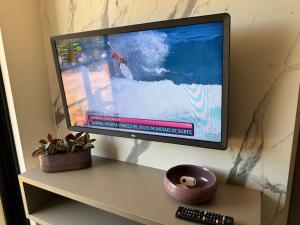 a flat screen tv sitting on top of a table at 2 quartos a beira-mar do Cabo Branco AH103 Fortune in Tambaú