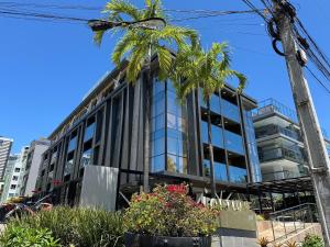 a building with palm trees in front of it at 2 quartos a beira-mar do Cabo Branco AH103 Fortune in Tambaú