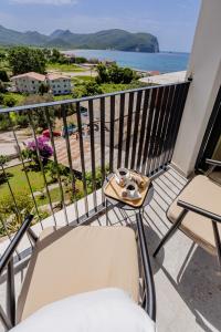 a balcony with a table and chairs and the ocean at Hotel AQUILO in Petrovac na Moru