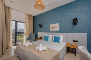 a bedroom with a large bed with a blue wall at Hotel AQUILO in Petrovac na Moru