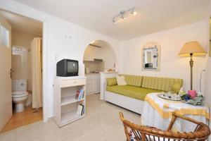 a room with a bed and a tv and a table at Leonardos Apartments in Naousa