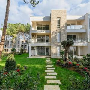 an exterior view of a building with a yard at Shiny San Pietro Apartment in Mullini i Danit