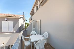 a balcony with two chairs and a table at Apartments Crnekovic IX in Baška