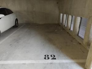 a parking garage with a white car parked in it at Gosen appart in Athis-Mons