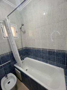 a bathroom with a bath tub and a toilet at Yousa Home & pool in Gzennaïa