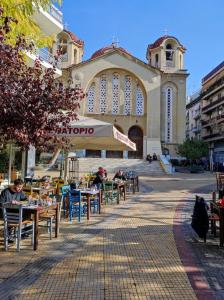 grupa stołów i krzeseł przed budynkiem w obiekcie LEGAS apartments w Atenach