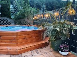 a hot tub on a patio with plants and lights at MOARI pokoje gościnne in Szczyrk