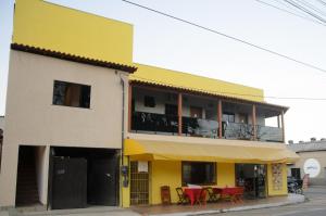 a yellow building with red tables in front of it at Aconchego Fabuloso in Penedo