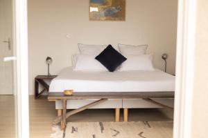 a bedroom with a bed with white sheets and pillows at Grande maison, piscine. 15 personnes. Sancerre in Gardefort +37 photos