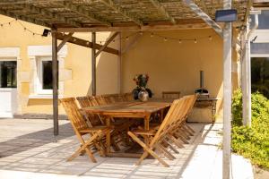 a wooden table and chairs on a patio at Grande maison, piscine. 15 personnes. Sancerre in Gardefort