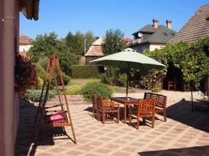 un patio con mesa, sillas y sombrilla en Apartment Najadka en Bobrovec