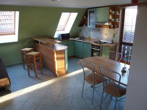 a kitchen with green cabinets and a table and chairs at Apartment Najadka in Bobrovec