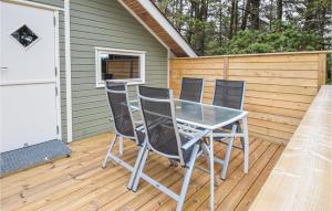 a table and chairs sitting on a deck at Awesome Home In Blåvand With Wifi in Blåvand +17 photos