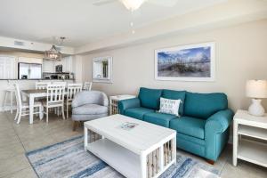 un soggiorno con un divano blu e un tavolo di Sea Dunes 402 a Fort Walton Beach