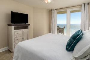una camera da letto con un letto, una TV e una finestra di Sea Dunes 402 a Fort Walton Beach