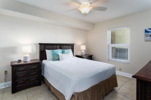 una camera da letto con un letto e un ventilatore a soffitto di Sea Dunes 402 a Fort Walton Beach Altre 49 foto