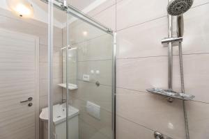 a bathroom with a glass shower with a toilet at Apartments Crnekovic IX in Baška +263 photos