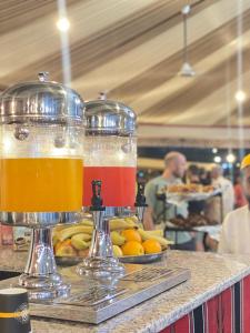 two glasses of drinks on a counter with fruit at Tulip Camp Wadi Rum in Wadi Rum
