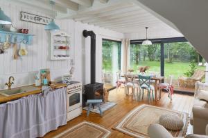 a kitchen with a stove and a table with chairs at Miejscówka nad Morzem in Ciekocino
