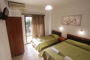 a hotel room with two beds and a window at Villa Herkules in Olympic Beach