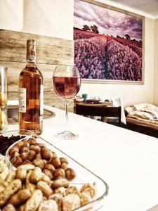 een glas wijn naast een bord eten en een wijnfles bij Villa 106 in Pawłów
