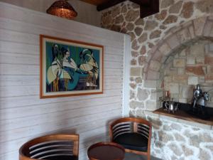 a room with two chairs and a painting on the wall at Rahoni Park & Suites in Dhërmi