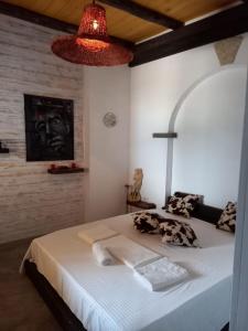 a bedroom with a large white bed with a lamp at Rahoni Park & Suites in Dhërmi