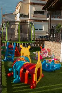 a playground with many toys on the grass at EmilyApartments 1 in Chrysoupolis