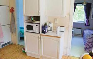 a kitchen with white cabinets and a microwave on a counter at Beautiful Home In Ljusterö With Kitchen in Laggarsvik