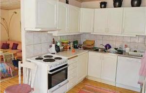 a kitchen with white cabinets and a stove top oven at Beautiful Home In Ljusterö With Kitchen in Laggarsvik