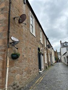 a brick building with windows and a street at Golfers Rest in Ayr