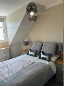 a bedroom with a large bed with two pillows at Golfers Rest in Ayr