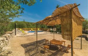 - une table et des chaises sous un parasol à côté de la piscine dans l'établissement Three-Bedroom Holiday Home In Lecevica, à Lećevica