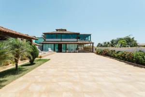 a large house with a walkway in front of it at Casa de Praia c/ Piscina e Área Gourmet | AGV 1 in Fazendinha