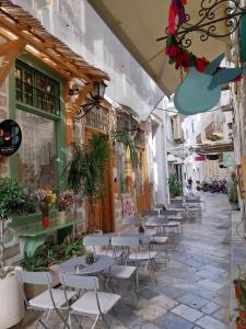 a patio with tables and chairs in a building at Homdwell Fine Living 2 in Ermoupoli