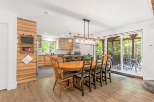 een keuken en eetkamer met een houten tafel en stoelen bij Natur Rustik - En pleine nature avec Spa in Petite-Rivière-Saint-François