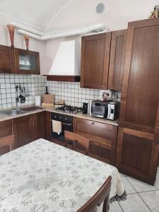 a kitchen with wooden cabinets and a table and a microwave at La home del melograno in Turin