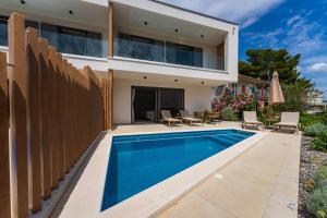 a house with a swimming pool and a fence at Villa Cvita east in Primošten