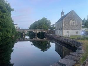 a stone bridge over a river next to a building at Riverside Studio Apartment in Donegal