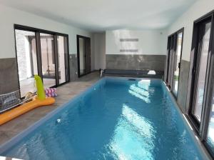a large swimming pool with blue water in a house at Villa Ty Varcq in Locquirec