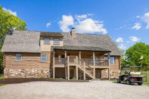 a large log cabin with a golf cart in front of it at 216 Ridge Lane in Branson