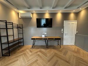 Pokój ze stołem i telewizorem na ścianie w obiekcie Book-A-Room Salzburg Apartment 33 w mieście Salzburg