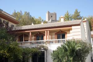 a house with a balcony with a castle in the background at Alcalá del Jucar Hotel Pelayo in Alcalá del Júcar