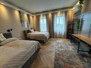 sypialnia z 2 łóżkami, stołem i biurkiem w obiekcie Book-A-Room Salzburg Apartment 33 w mieście Salzburg