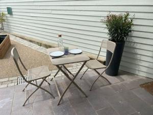 a table and two chairs and a bottle on a patio at Beau studio neuf et équipé in Blacé