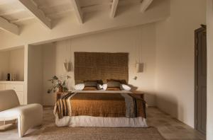 a bedroom with a bed and a chair at Hotel Rural Sant Ignasi in Ciutadella