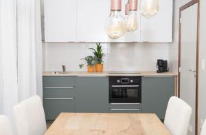 a kitchen with white cabinets and a wooden table at Lila 23 appartement 1 Arnoud in Blankenberge