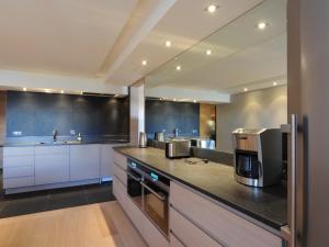 a kitchen with white cabinets and a black counter top at Charmant T4 rénové proche pistes, parking, Wifi - FR-1-575-33 in Courchevel